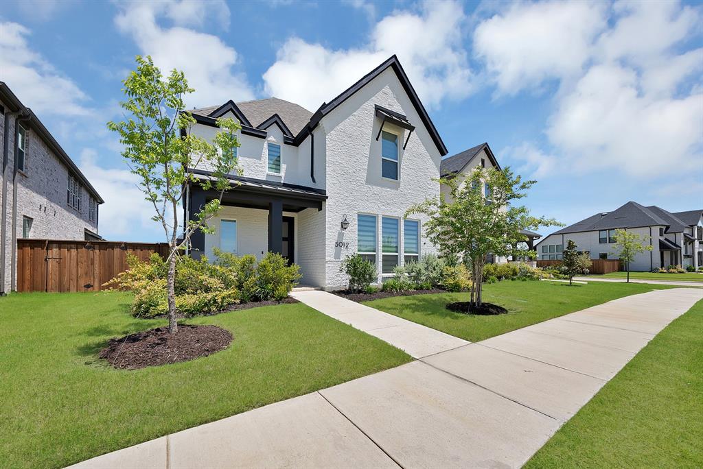 5012 Triadic Lane Prosper, TX 75078 - Photo 3 of 38 White brick exterior with contrasting dark trim, featuring a covered entry and decorative window awnings