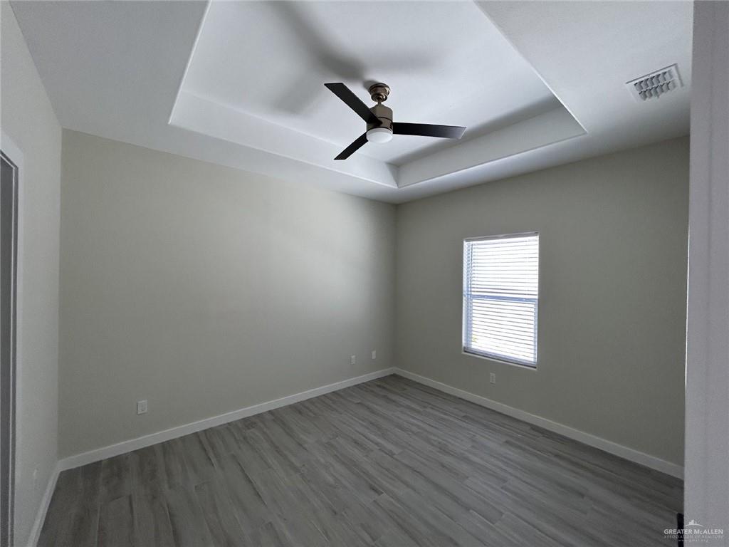 1320 North McColl Road, Unit 2 Edinburg, TX 78541 - Photo 16 of 24 an empty room with wooden floor fan and windows