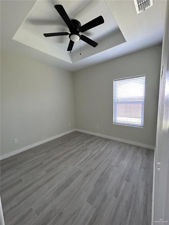 1320 North McColl Road, Unit 2 Edinburg, TX 78541 - Photo 22 of 24 an empty room with wooden floor ceiling fan and windows