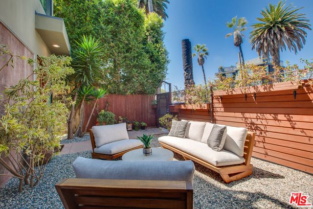 a living room with patio furniture and a potted plant