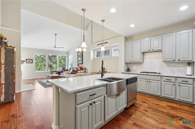 a kitchen with stainless steel appliances granite countertop a sink stove and refrigerator