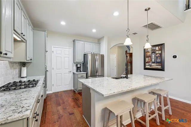 a kitchen with stainless steel appliances granite countertop a stove refrigerator and cabinets