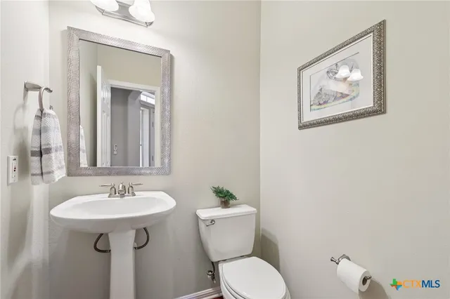 a bathroom with a sink mirror and toilet