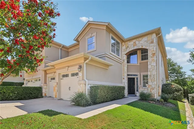 a front view of a house with a yard and trees