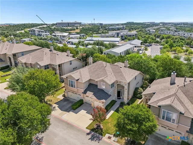 an aerial view of residential houses with outdoor space and trees
