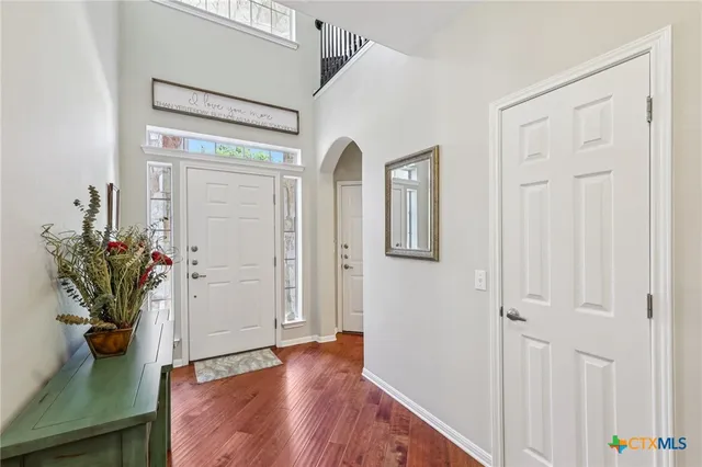 a view of a hallway with wooden floor and a potted plant