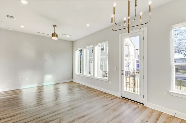 a large kitchen with stainless steel appliances kitchen island a large counter top and a chandelier