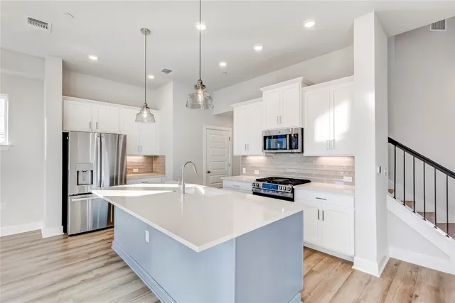 a view of kitchen with stainless steel appliances granite countertop refrigerator sink and stove