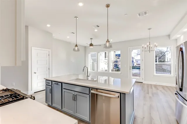 a large kitchen with kitchen island a sink stainless steel appliances and cabinets