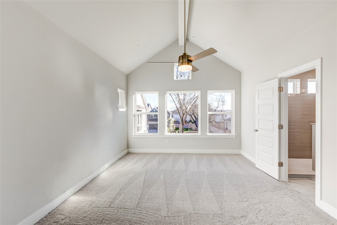 715 Bernese Pass Austin, TX 78745 - Photo 19 of 38 Spare room with light colored carpet, beam ceiling, healthy amount of natural light, a ceiling fan, and high vaulted ceiling