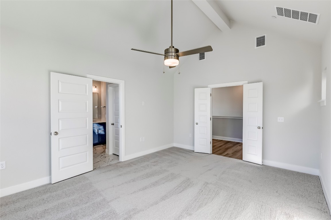 715 Bernese Pass Austin, TX 78745 - Photo 21 of 38 Unfurnished bedroom featuring beamed ceiling, a spacious closet, high vaulted ceiling, light carpet, and ceiling fan