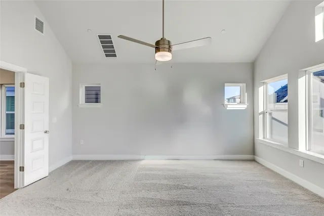 an empty room with closet and a ceiling fan