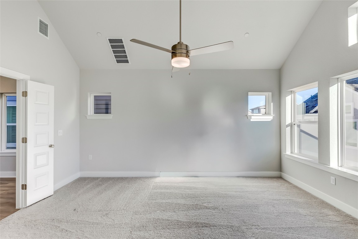 715 Bernese Pass Austin, TX 78745 - Photo 22 of 38 Unfurnished room featuring high vaulted ceiling, ceiling fan, and light carpet