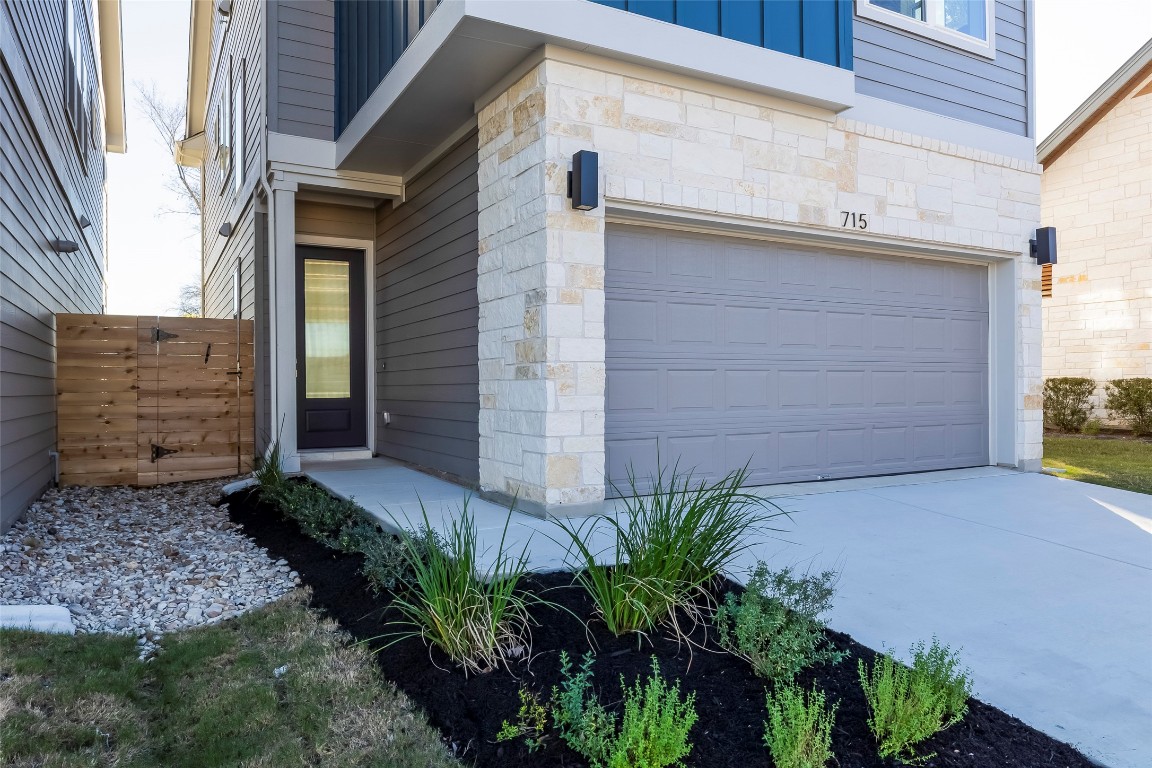 715 Bernese Pass Austin, TX 78745 - Photo 4 of 38 Doorway to property featuring stone siding, an attached garage, and concrete driveway