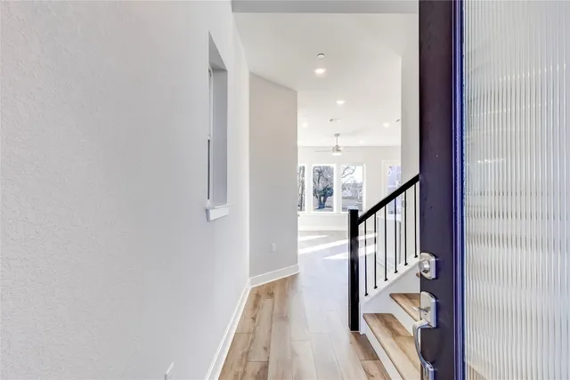a view of a hallway with wooden floor and staircase