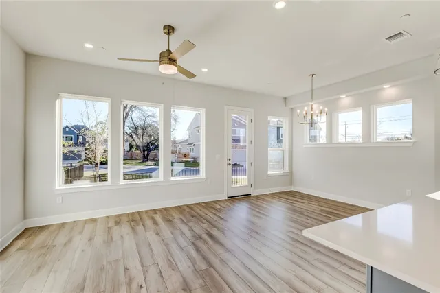 a large kitchen with cabinets wooden floor and a window