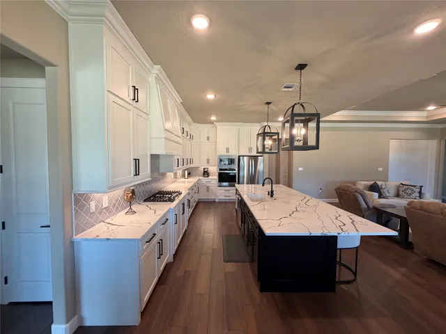 a large kitchen with a table chairs and a wooden floor