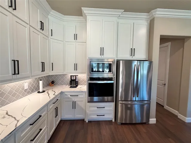 a kitchen with white cabinets and stainless steel appliances