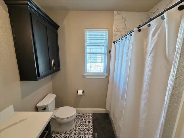 a bathroom with a toilet a sink and a shower