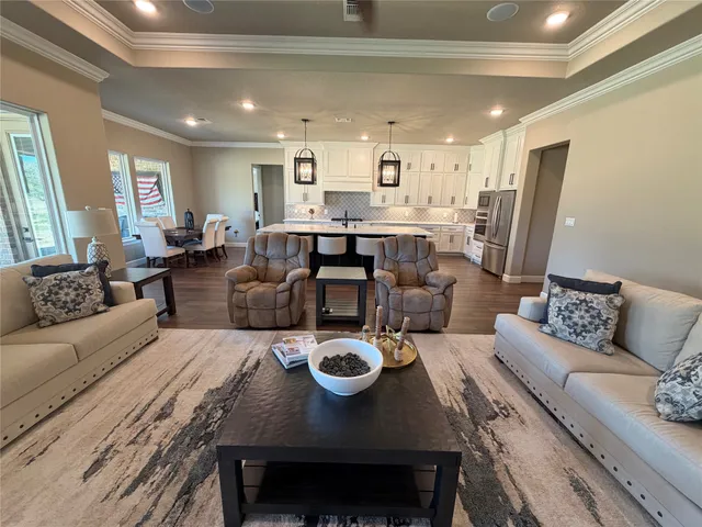 a living room with furniture a kitchen view and a chandelier