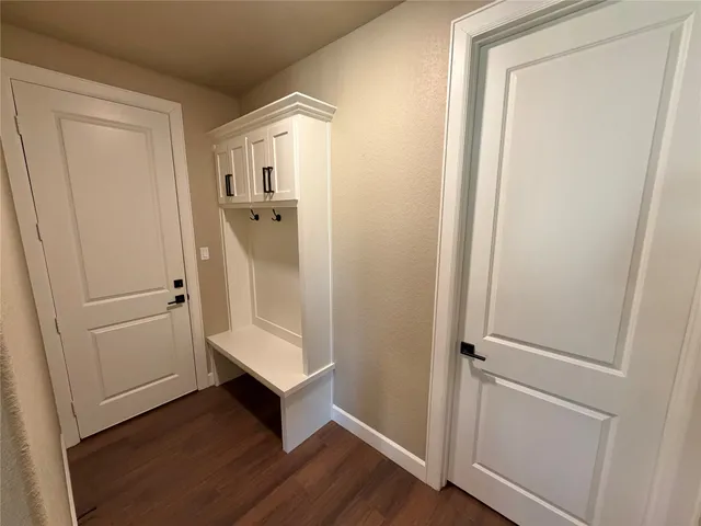 a view of a hallway with wooden floor and entryway
