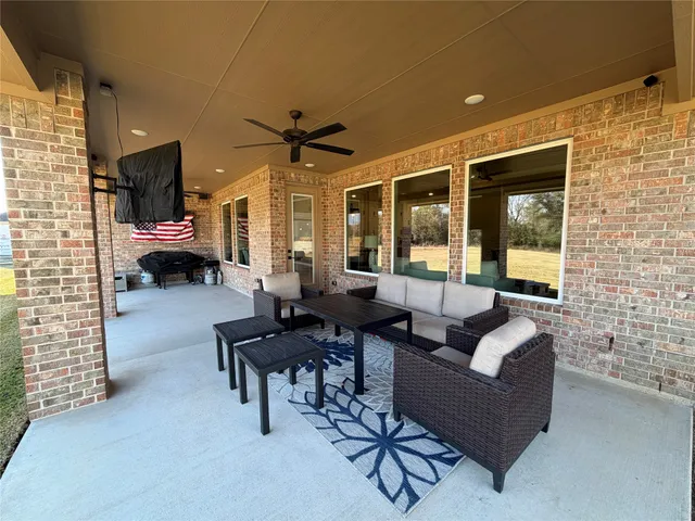a living room with patio furniture and a floor to ceiling window