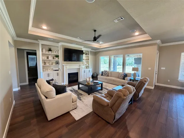 a living room with furniture a flat screen tv and a fireplace