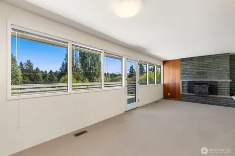 a view of an empty room with a fireplace and a window