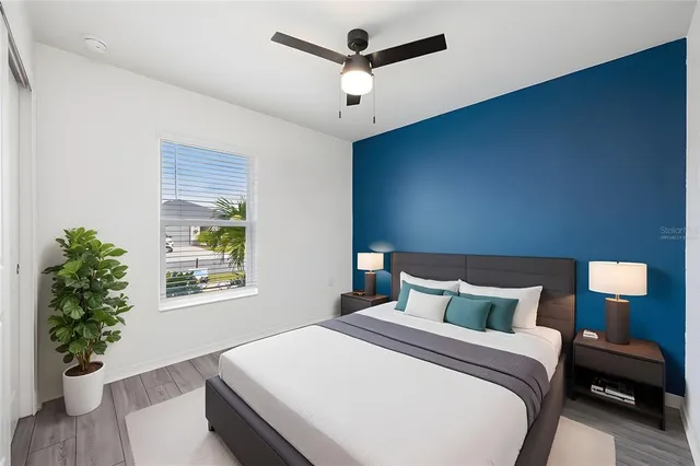 a bedroom with a bed and a potted plant