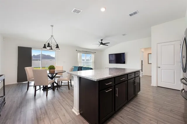 a kitchen with a table chairs and wooden floor