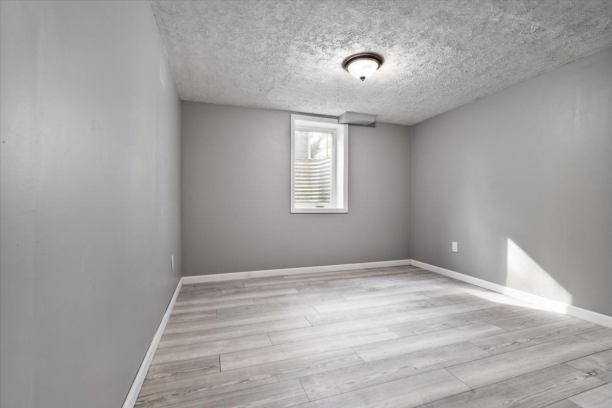 415 Bradley Lane Normal, IL 61761 - Photo 22 of 28 a view of an empty room with a window and wooden floor