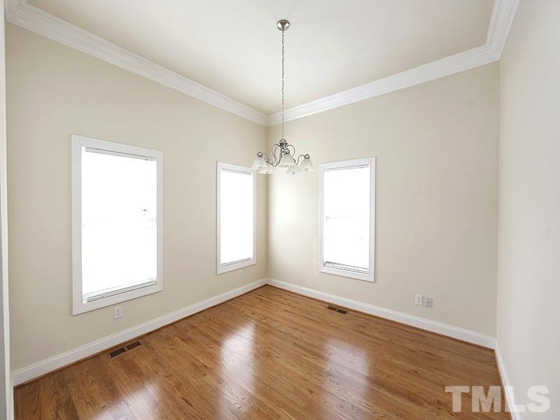 1009 Fieldgrass Place Raleigh, NC 27603 - Photo 4 of 12 a view of an empty room with a window and wooden floor