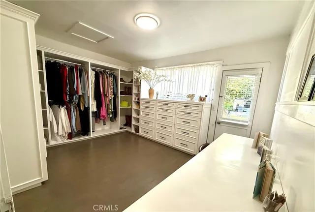 a view of walk in closet with clothes and shoes