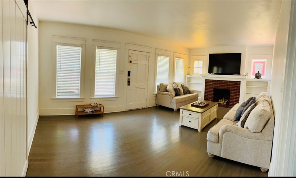 6226 Washington Whittier, CA 90601 - Photo 2 of 21 a living room with furniture a flat screen tv and a fireplace