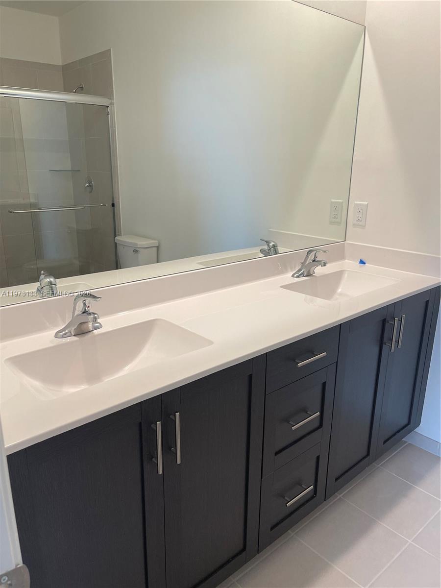 20564 Northeast 5th Place Miami, FL 33179 - Photo 12 of 38 a bathroom with a double vanity sink and a mirror
