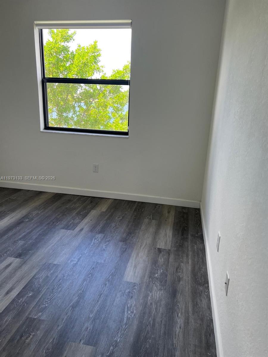20564 Northeast 5th Place Miami, FL 33179 - Photo 19 of 38 an empty room with wooden floor and windows