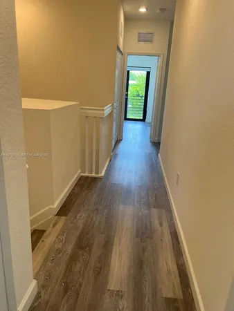 an empty room with wooden floor and a window