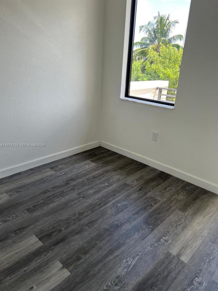20564 Northeast 5th Place Miami, FL 33179 - Photo 28 of 38 a view of an empty room with wooden floor and a window