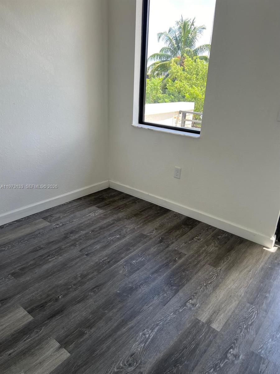 20564 Northeast 5th Place Miami, FL 33179 - Photo 29 of 38 an empty room with wooden floor and windows