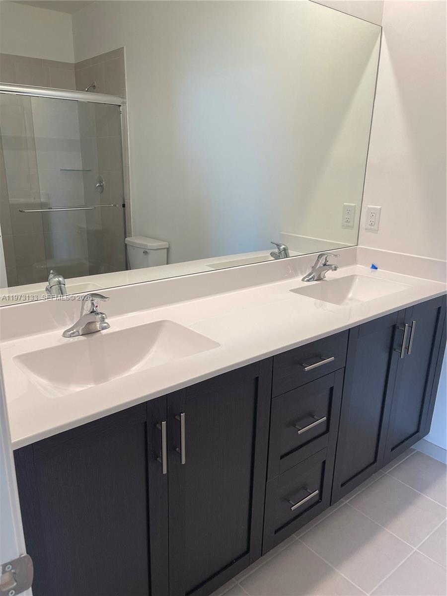 20564 Northeast 5th Place Miami, FL 33179 - Photo 4 of 38 a bathroom with a double vanity sink and a mirror