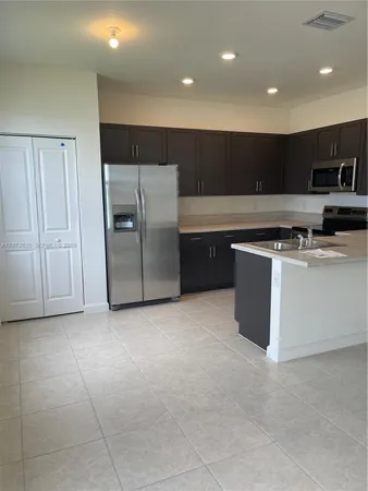 a kitchen with stainless steel appliances granite countertop a stove a refrigerator a sink and a microwave