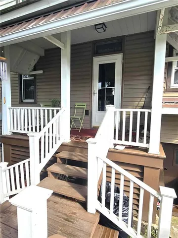 a front view of a house with a yard and tree s