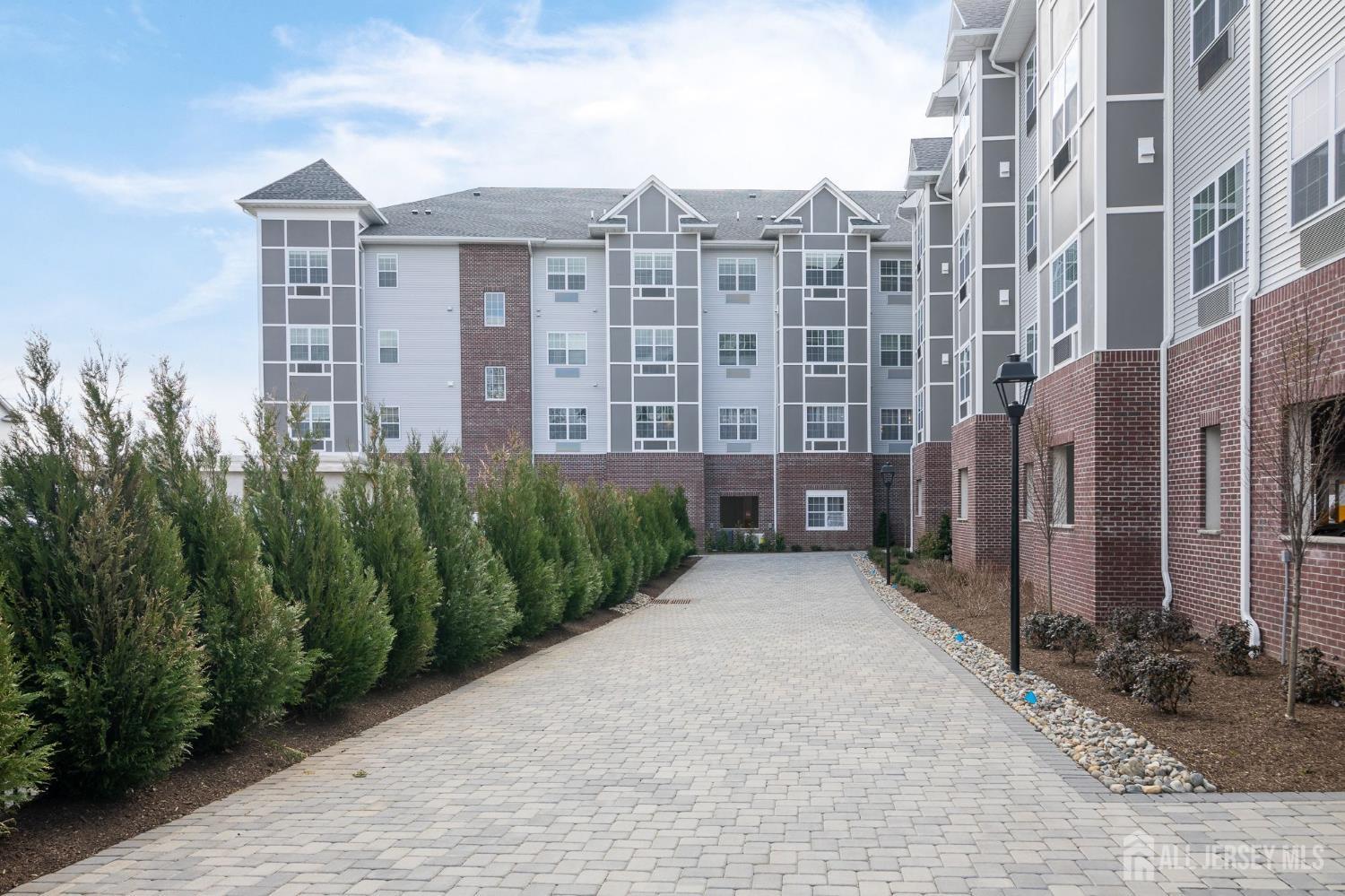 175 Quincy Court, Unit B406 Hopelawn, NJ 08861 - Photo 12 of 12 a view of a brick building next to a yard