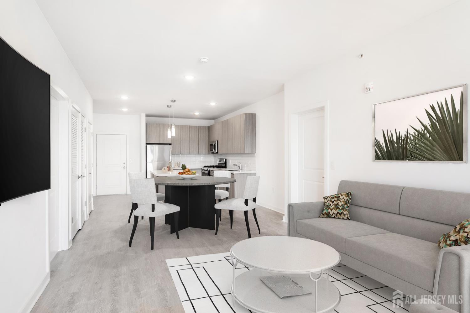 175 Quincy Court, Unit B406 Hopelawn, NJ 08861 - Photo 8 of 12 a living room with furniture and a dining table with kitchen view