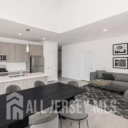 a kitchen with stainless steel appliances kitchen island granite countertop a sink a stove a table and chairs