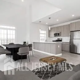 a view of a hallway with wooden floor and chandelier