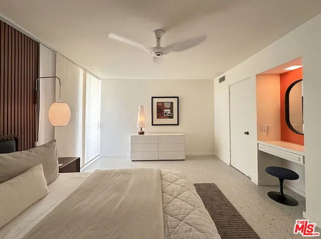 a bedroom with a large bed and a chandelier