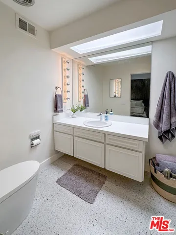 a bathroom with a sink a toilet and a mirror
