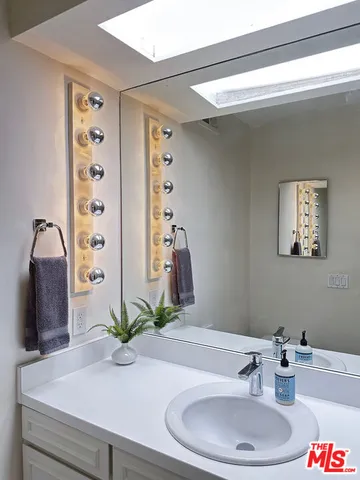 a bathroom with a sink a toilet and a mirror