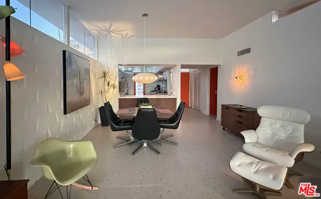 a living room with furniture and a painting on the wall